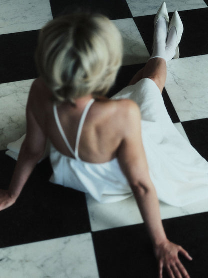 Krótka sukienka SOLEA off-white z odkrytymi plecami i krzyżowanymi ramiączkami, Marieta Żukowska x Muuv, dostępna na beetles.shop.