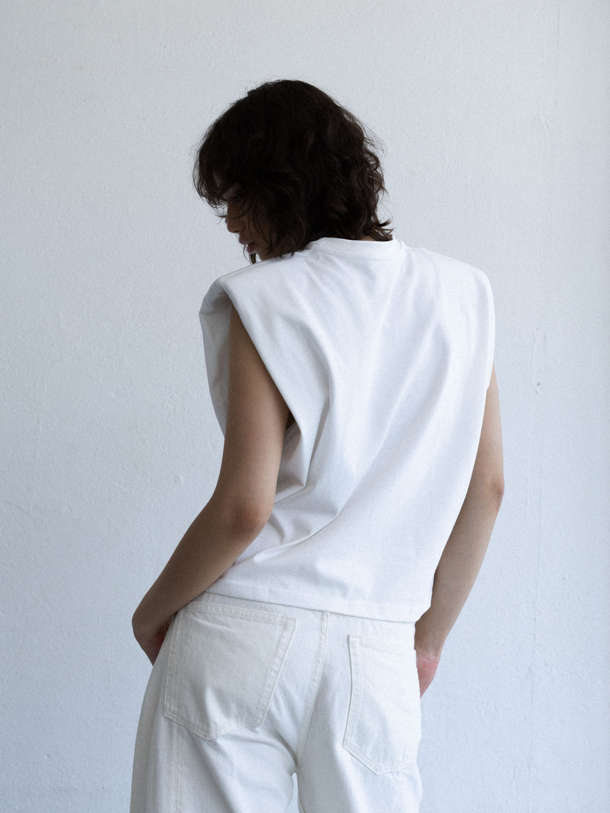 Top BLEA off-white pokazany z tyłu, prosty fason bez rękawów i poszerzone ramiona, kolekcja Mariety Żukowskiej dla Muuv, beetles.shop.