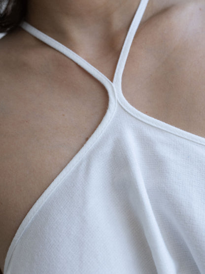 Zbliżenie dekoltu halter sukienki SOLEA off-white o rozkloszowanym kroju, Marieta Żukowska x Muuv, dostępna na beetles.shop.